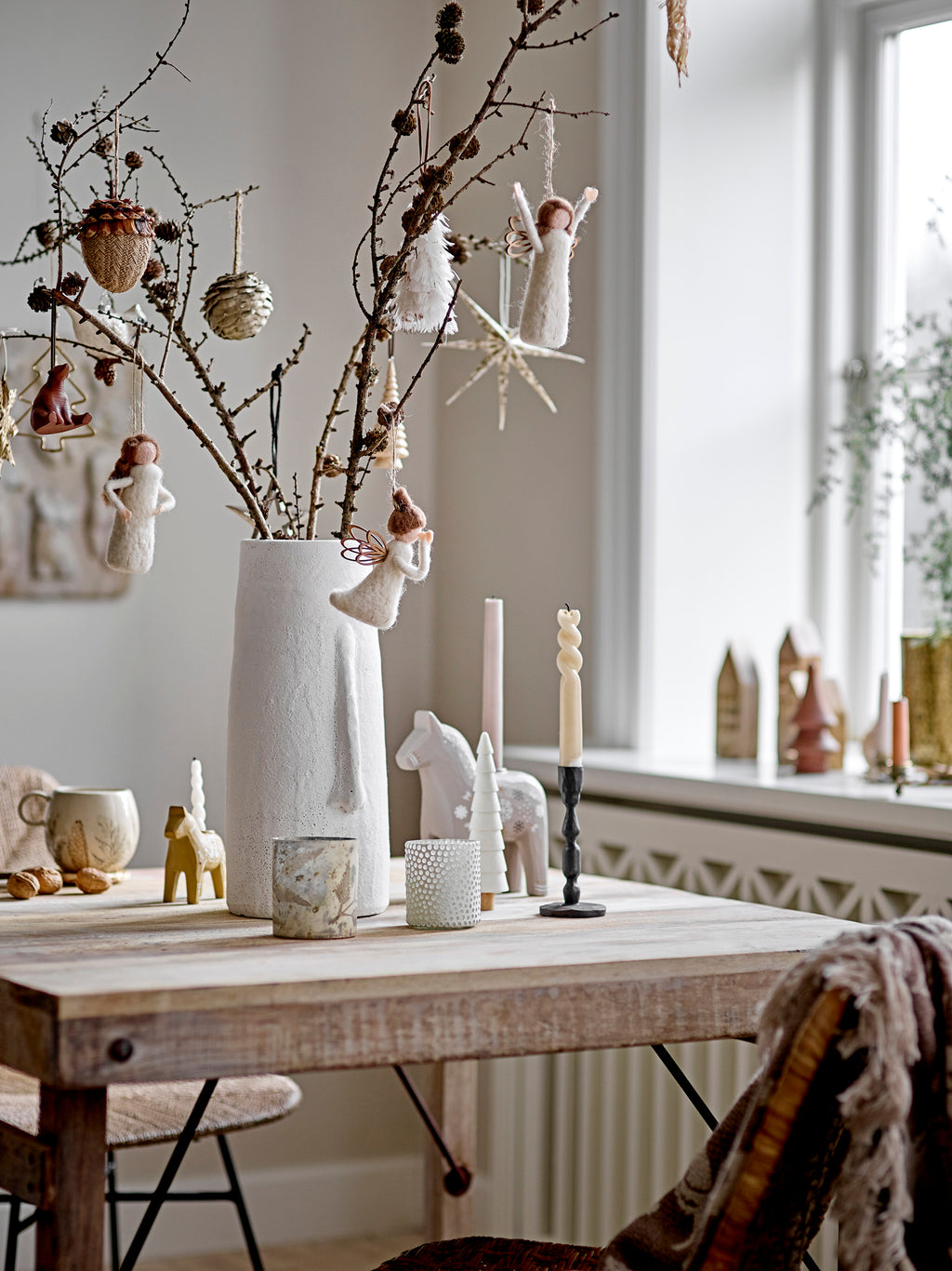 Siffer Kerzenhalter von Bloomingville auf einem Holztisch neben einer Vase mit Zweigen und Weihnachtsschmuck